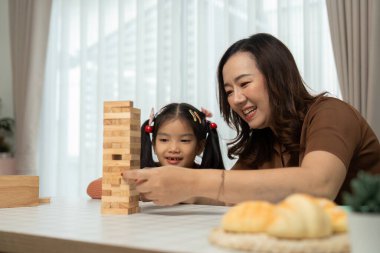 Bir anne kızına bir sanat aktivitesinde rehberlik eder, yaratıcılığını ve öğrenimini arttırır. Bu besleyici ortam keşif ve sanatsal ifadeyi teşvik eder.