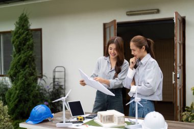 İki kadın mimar sürdürülebilir mimari, planlar ve çevre dostu unsurlar içeren bir model hakkında bir tartışmaya giriştiler..