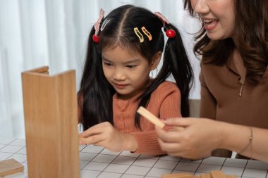 Genç bir kız ve annesi yaratıcı bir seanstan zevk alıyorlar. Tahta bloklarla yapılar inşa ediyorlar. Okul başlamadan önce erken öğrenme ve bağlanma dönemlerini teşvik ediyorlar..