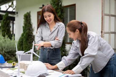 Mimarlardan oluşan bir ekip, yenilikçi tasarımlar ve gelecekteki inşaatlar için çevre dostu materyalleri tartışan sürdürülebilir bir inşaat projesinde işbirliği yapıyor..