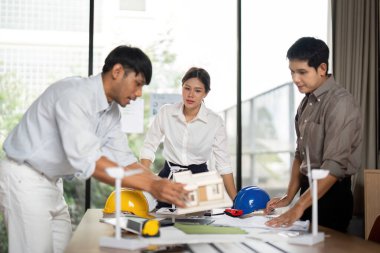 Çeşitli mühendislik ekipleri sürdürülebilir mimari planları, takım çalışması ve ofis ortamında yenilik üzerine işbirliği yaparlar..