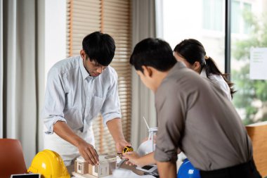 Mühendisler gelecekteki projelerde sürdürülebilirliği destekleyen tasarım stratejilerini değerlendirerek yeşil mimari planlamasına odaklanıyorlar..