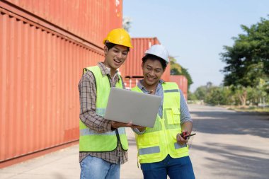 Mühendisler, bir dizüstü bilgisayardaki lojistik verileri incelerken, etkili takım çalışmalarını göstererek fikir ve görüşlerini paylaşıyorlar..