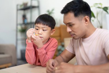 Bir baba ve oğul birlikte bilim modelleri inşa ediyorlar, evde etkileşimli bir öğrenme deneyimi yaşıyorlar..