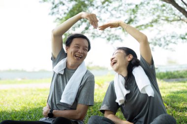 Yoga esneme hareketleri yapan neşeli, son sınıf çifti arasında neşeli bir an..