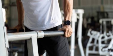 Genç bir adam jimnastik salonunda dalgıçlık yapıyor, üst vücut gücüne ve genel sağlık eğitimine odaklanıyor..