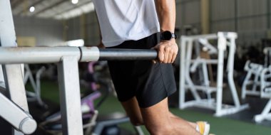 Odaklanmış bir adam spor salonunda dalış yaparak, sağlığını ve fiziksel kondisyonunu yükselterek güç eğitimine başlar..