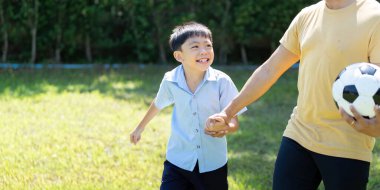 Bir baba ve oğul, güneşin altında futbol oynayıp, aile aktivitelerini ve açık hava eğlencesini ön plana çıkaran keyifli bir anı paylaşıyor..