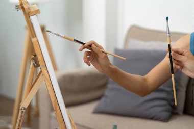 İki kadın birlikte resim yaparken yaratıcılık anlarını paylaşıyor, rahat bir yaşam alanında sanatsal işbirliği ve bağlarını sergiliyorlar..