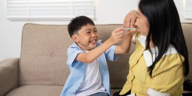 Genç bir çocuk, bir yuva ortamında neşe ve kahkaha paylaşarak annesiyle neşe içinde bağ kuruyor..