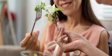 Yaşlı bir çift neşe dolu bir anı paylaşıyor, bir bardak suyla kadeh kaldırıyor, günlük yaşamlarındaki sağlık ve susuzluğu vurguluyor..