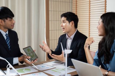 Çeşitli bir ekip, işbirlikçi bir çalışma alanında ESG ilkelerine odaklanarak sürdürülebilir iş stratejilerini aktif olarak tartışmaktadır..