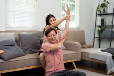 Yaşlı bir çift, sıcak oturma odalarında birlikte egzersiz yapmaktan, sağlıklarını geliştirmekten ve birbirlerine bakmaktan hoşlanırlar..