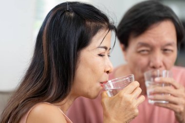 Yaşlı bir çiftin içme suyu çekimleri, sağlığa ve sağlıklı yaşama bağlılıklarını gösteriyor..