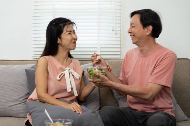 Sevgi dolu yaşlı bir çift taze bir salatanın tadını çıkarıyor, sağlıklı bir yaşam ve sıhhatli bir evde yaşıyor..