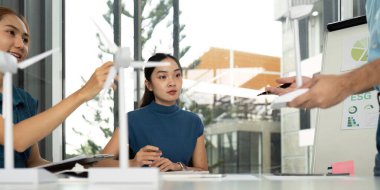 Bir ekip üyesi, ESG girişimlerini sunarken dikkatle dinliyor ve tartışmalarında sürdürülebilirliği vurguluyor.