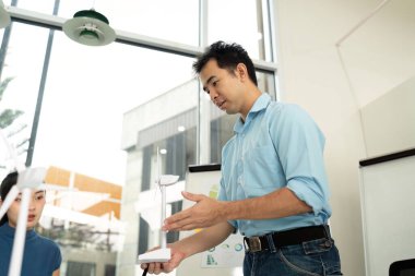 Bir profesyonel, ESG girişimleri ve sürdürülebilirlik konulu bir toplantıda çevre modelini açıklar.