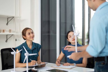 Çeşitli profesyonellerden oluşan bir grup, sürdürülebilir enerji çözümleri ve rüzgar enerjisi üzerine bir tartışmaya girişiyor..