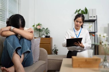 Bir psikolog, duygusal desteğin ve tedavi sürecinin önemini vurgulayan bir hasta duygularını ifade ederken not alır..