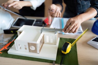 Mühendisler, yenilikçi tasarım ve çevresel hususlara odaklanarak sürdürülebilir bir mimari modeli ölçer ve tartışır..