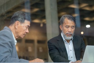 Bir proje üzerinde çalışan iki yaşlı adam, takım çalışmasını ve profesyonel bir çevrede tecrübenin önemini vurguladı.