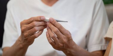 Yaşlı bir çift, evdeki sağlık belirtilerini kontrol ederken, ilişkilerindeki refah ve desteği vurgulayarak şefkatli bir anı paylaşıyor..