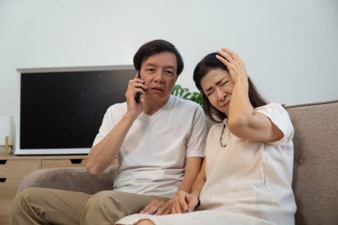 Rahat bir oturma odasında, yaşlı bir adam sıkıntılı ortağını teselli ederken telefonda konuşur. Sağlığa ve duygusal desteğe odaklan..