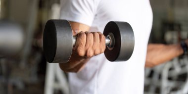 Formda bir adam halter egzersizi yapar. Spor salonundaki dayanıklılık eğitimini ve kondisyonunu ön plana çıkarır..