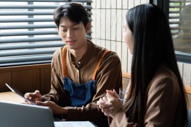 İki genç profesyonel, çağdaş bir ofis ortamında fikirlerini ve sezgilerini paylaşarak ortak bir tartışmaya giriştiler..