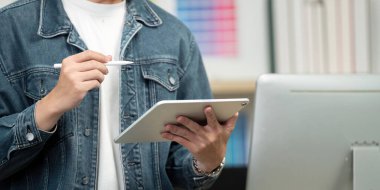 Yaratıcı bir birey bir tablet ve stil bulundurur, tasarım sürecinde yer alır, modern dijital sanatları canlı bir çalışma alanına yansıtır..