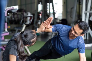 İki arkadaş eglenceli bir antrenman seansindan zevk aliyor, egsersiz yaparak ekip çalismasi ve saglik sergiliyorlar..