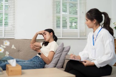 Bir psikolog, bir terapi ortamında stres duygularını ifade eden, güven ve duygusal destek ortamı oluşturan bir hastayı gözlemler..