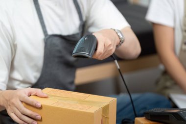 Bir çift etkili bir şekilde barkod tarayıcı ile paketleri tarar, üretkenlik odaklı bir lojistik ortamında takım çalışması gösterir.