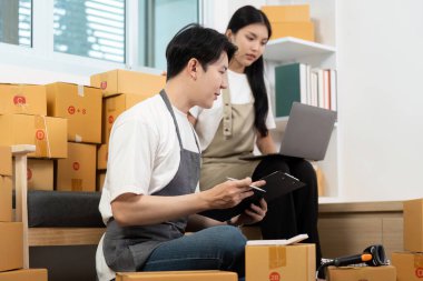 Bir çift evlerinde birlikte çalışıyor, paketlerini düzenliyor ve online mağazalarının envanterlerini yönetiyor. Takım çalışması ve girişimciliğe odaklan.