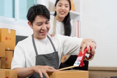 Bir çift, eşyalar paketlenirken, takım çalışması sergilerken ve nakliye ortamında pozitif enerji üretirken neşeli bir anı paylaşıyor..