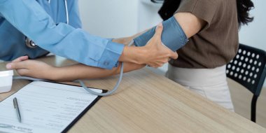 Bir hemşire hastalara kan basıncını ölçmek için sphygmomanometre kullanır..