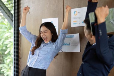 Modern ofis ortamında başarılarını coşku ve heyecanla kutlayan bir takım..