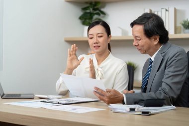 Bir iş kadını, işbirliği ve stratejik planlamayı vurgulayarak iş arkadaşına mali belgeler sunar..