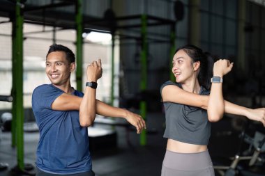 Spor salonunda esneme egzersizlerine katılan iki arkadaş, antrenmanlarına hazırlanırken arkadaşlığı ve sağlığı destekliyor..