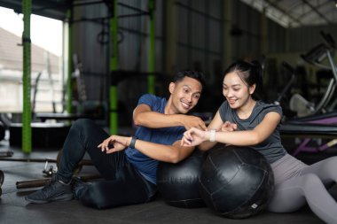 Spor salonundaki antrenmanlarının keyfini çıkarırken, takım çalışmasının ve motivasyonun önemini vurgulayan dostane bir ikili spor danışmanlığı yapıyor..