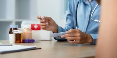 Bir sağlık hizmeti sağlayıcısı tıbbi bir doz hazırlar, klinik ortamda profesyonellik ve hastanın güvenliğine dikkat gösterir.