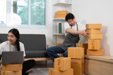 Ofislerinde şakacı bir çift, tek bir partneri, istiflenmiş kutuları dengelemek için esprili bir şekilde mücadele ediyor, eğlence ve takım çalışması sergiliyor..