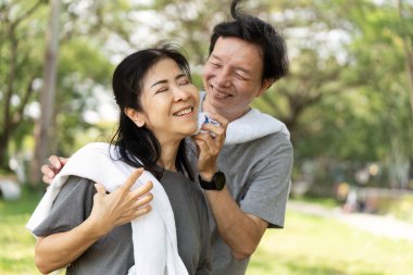 Bir çift, açık havada egzersiz yaparken neşeli bir anı paylaşıyor. Bağlantının ve sağlıklı yaşamın altını çiziyor..