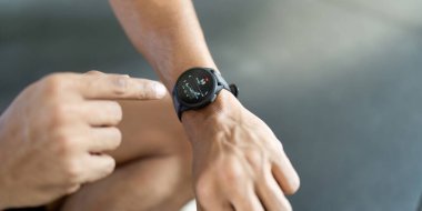 Bir adam, kişisel sağlığa teknolojinin entegrasyonunu gösteren verileri gözden geçirmek için ukalalığını gösterir..