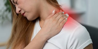 Genç bir kadın omzuna dokunuyor ve rahatsızlığını dile getiriyor. Bu görüntü, sağlık farkındalığının ve özgüvenin öneminin altını çizmektedir..