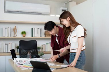 İki genç profesyonelin kullanıcı deneyimi tasarım kavramları hakkında fikir ve geribildirim paylaştığı canlı bir çalışma alanı.