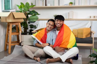 Gökkuşağı bayrağının altında kucaklaşan iki eşcinsel adam, yeni yaşam alanlarında aşklarını ve kapsayıcılıklarını kutluyorlar..