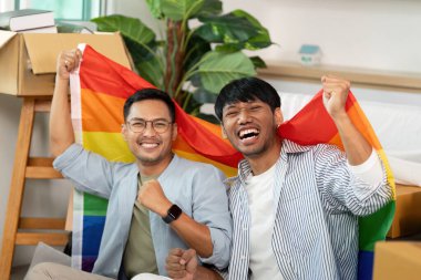 Gururlu bayraklar tutan iki neşeli gay, aşklarını ve birlikteliklerini kutluyorlar. Parlak, hoş bir yaşam alanında..