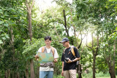 Bir baba ve oğul doğa yürüyüşleri sırasında birlikte bir harita incelerler, vahşi doğadaki keşiflerini ve takım çalışmalarını vurgularlar..