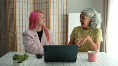 İlgili bir kız, yaşlı annesine bilgisayar kullanmayı, dijital okuryazarlığı, nesiller arası eğitimi ve modern teknolojiyi benimsemeyi öğrenmesinde yardımcı olur..